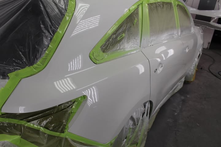 A car masked and prepped for refinishing in the spray booth